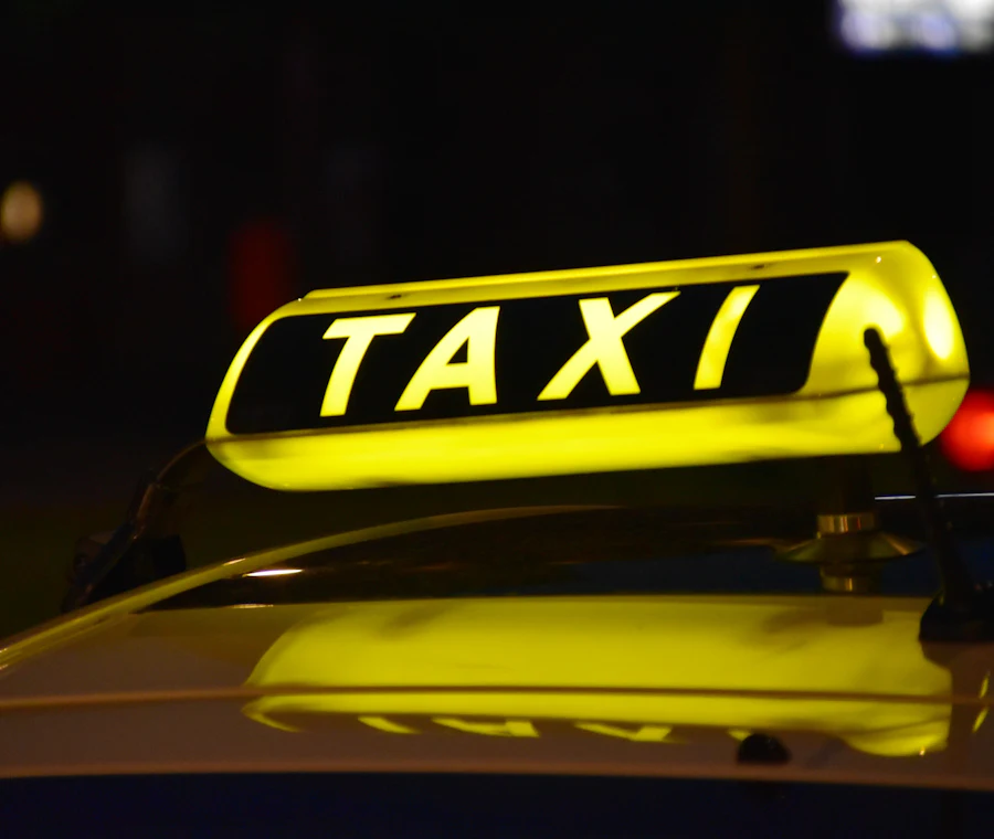 Podświetlony znak TAXI na dachu samochodu nocą